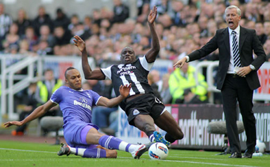 Younes Kaboul of Tottenham Hotspur tackles Demba Ba of Newcastle United
