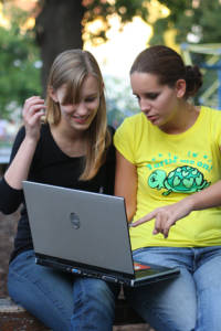 Zwei Mädchen im Park beim Internet surfen